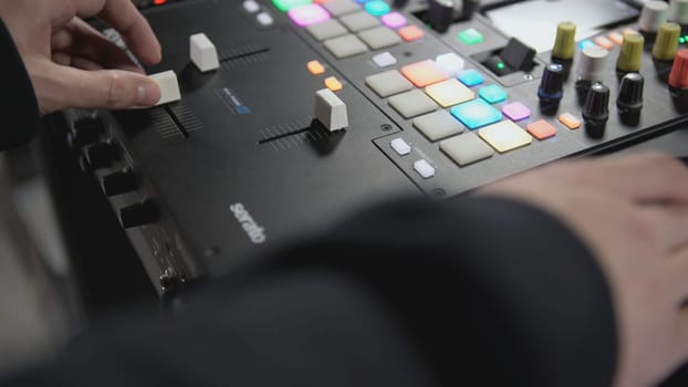 Click colored squares on mixer panel. ART. Hands in dark room are dialing code from multi-colored squares. Abstract music on mixer color board.