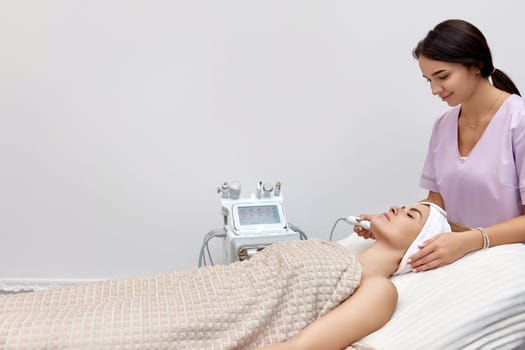 cosmetologist doing peeling procedure for female client in beauty salon