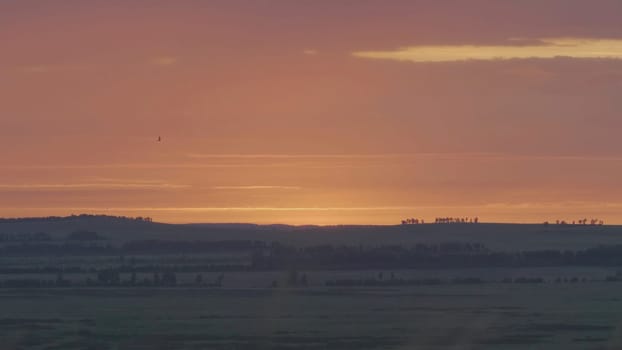 Natural Sunrise Over Field Or Meadow. Bright Dramatic Sky And Dark Ground. Countryside Landscape Under Scenic Colorful Sky At Sunset Dawn Sunrise. Sun Over Skyline, Horizon. Warm Colours.