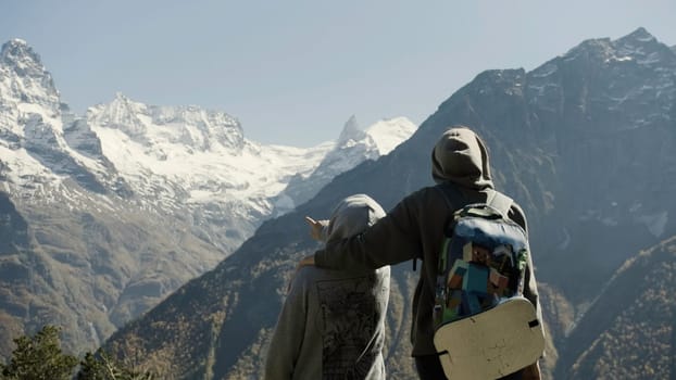 Alps cold mountain tops covered by snow and ice. Creative. Rear view of tourists couple watching winter calm nature