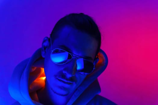 Cool man. Fashionable portrait. Colorful neon light. Stylish confident handsome male in trendy