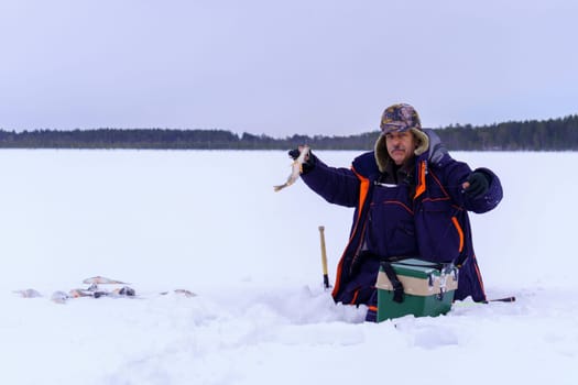 Man Holding a Fish in Hands. Winter fishing. Banner, copy space