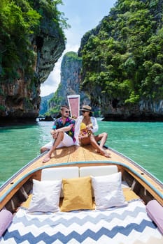 Luxury Longtail boat in Krabi Thailand, couple man, and woman on a trip to the tropical island 4 Island trip in Krabi Thailand. Asian woman and European man mid age on vacation in Thailand.