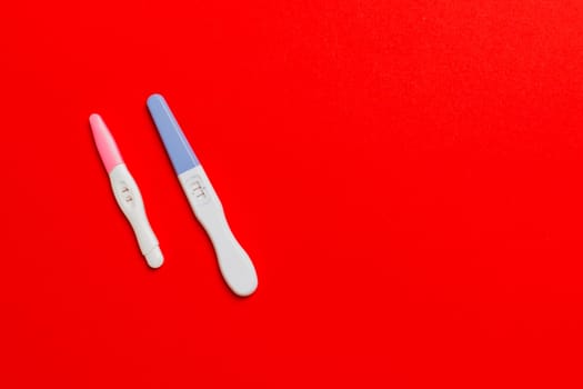 Colored Pregnancy test on colored background, top view with copy space.