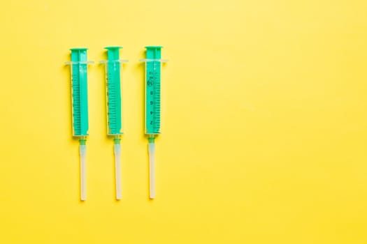 Top view of syringes in a row for medical injection on colorful background with copy space. Health and vaccination concept.