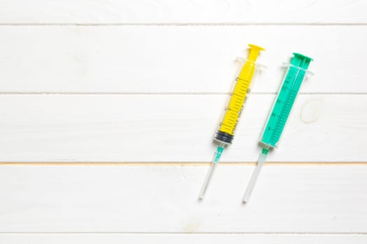 Top view of syringes on wooden background with copy space. Medical equipment for injection concept.