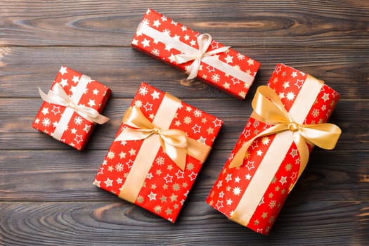 paper gift box with colored ribbon on dark wood background. top view with copy space Christmas holiday concept .