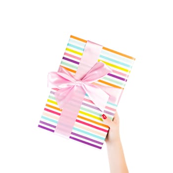 Woman hands give wrapped Christmas or other holiday handmade present in colored paper with pink ribbon. Isolated on white background, top view. thanksgiving Gift box concept.