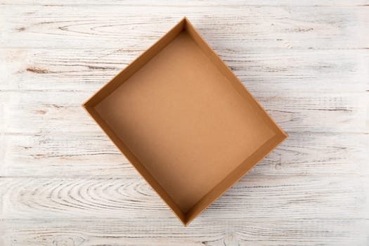 Empty Cardboard box on a white wooden background top view.