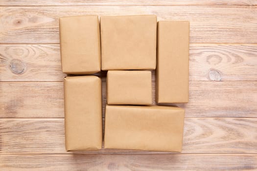 Brown mail package parcel blank for you design. Cardboard box on a wooden background.