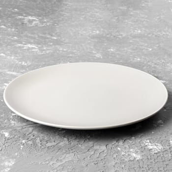 Perspective view. Empty white plate on wooden background.