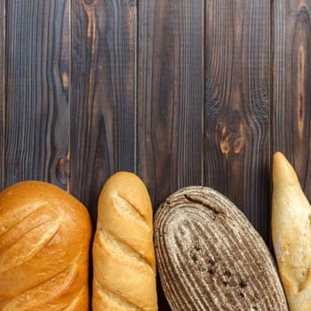 freshly baked bread on wooden background, top view.