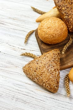 Rustic bread and wheat on an old vintage planked wood table. free text space.