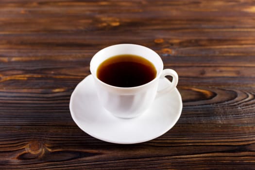 cup of coffee on wooden background add copy space for text.