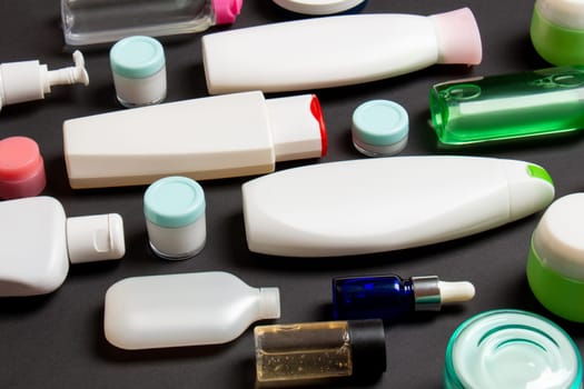 Top view of different cosmetic bottles and container for cosmetics on colored background. Flat lay composition with copy space.