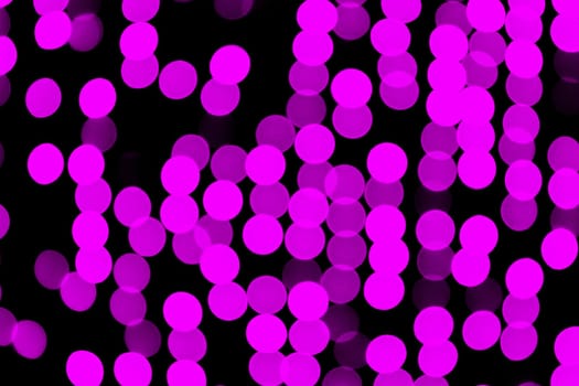 Unfocused abstract pink bokeh on black background. defocused and blurred many round light.