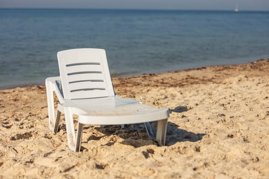 white plastic lounger on the background of the sea