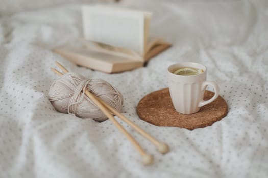 yarn and a cup of coffee on the bed. Hygge lifestyle, cozy mood. Handicraft day concept.