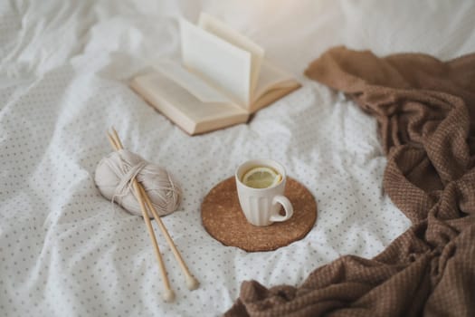 yarn and a cup of coffee on the bed. Hygge lifestyle, cozy mood. Handicraft day concept.