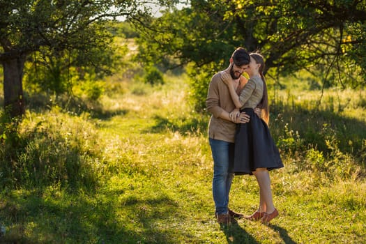 girl says something in the ear of her boyfriend, walking in nature