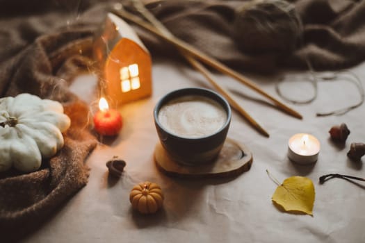 Autumn still life details in cozy home interior with a cup, candles, plaid. Hygge home decor. Halloween and Thanksgiving concept. Autumn banner