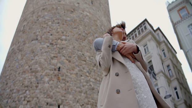 A gorgeous couple of young people. Action.A couple embracing on a city street, shot from different angles against the background of large towers and the sky. High quality 4k footage