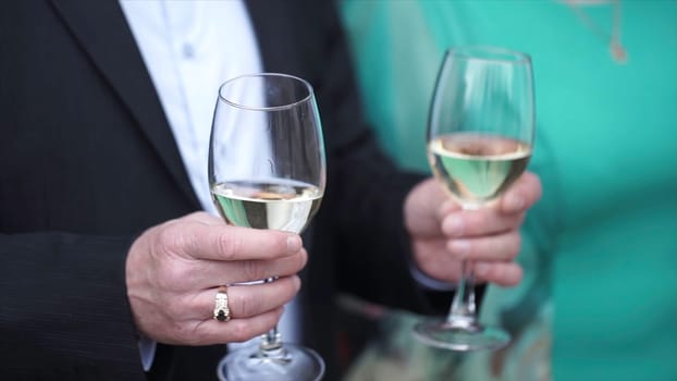 Senior man is standing with a glass of champagne. Old man with glasses of champagne.