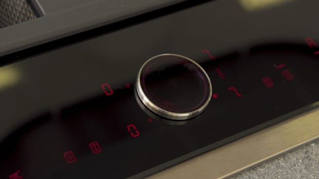 Man hand touching control panel on electric oven in the kitchen. Close up of male hand turning on and setting cooking mode on electrical hob.