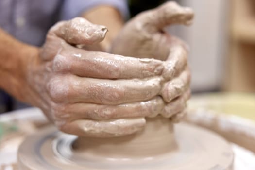 male hands making ceramic cup on pottery wheel, Close-up