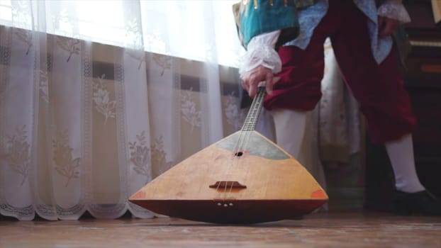Balalaika wooden in the hands of the musician. Stock. Folk musical art of the rural traditional. Musician from the past with balalaika.