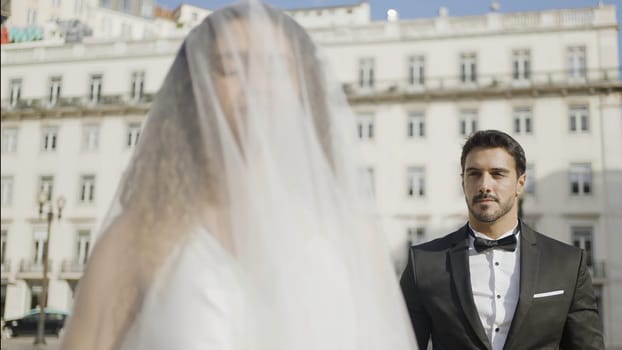 Portrait of a gentle brunette wife with her groom standing behind in a suit. Action. Concept of starting family