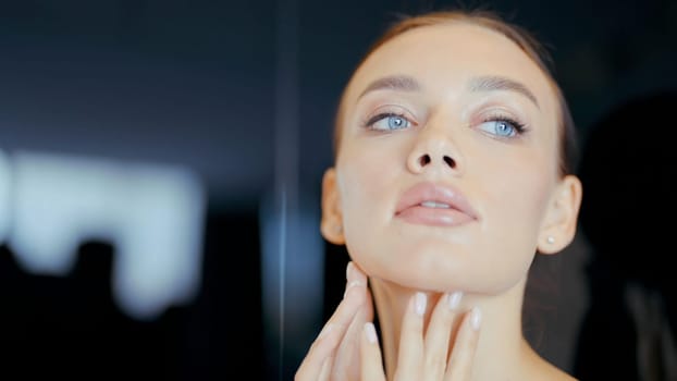 A woman after cosmetology services. Action. A person with bright blue eyes touches her body and face with her hands after massages and face masks