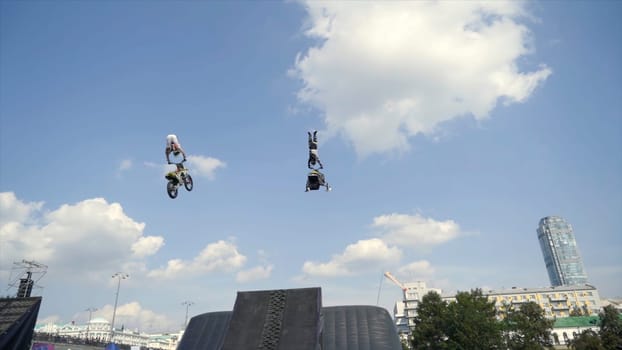 Motorcyclist performs stunts with jump in Moto festival. Action. Performance with motorcycle and snowmobile on springboard of Moto festival.