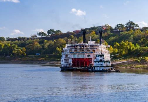 Natchez, MS - 26 October 2023: Paddle steamer river cruise boat American Queen docked in low water under the hill in Natchez Mississippi