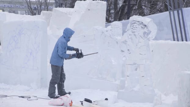 Orthodox Holiday Of Epiphany. Making Ice-Hole For Winter Swimming. Man Carving An Iced water or snow Sculpture On The Street. Winter HD