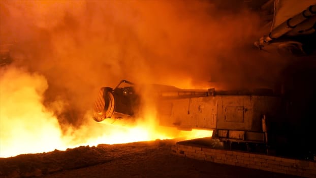 Molten steel pouring process with steam clubs at metallurgical plant. Close up fot steel pouring machine.