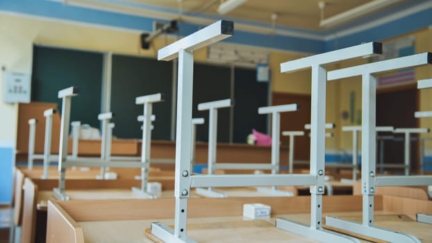 The concept of graduating from high school. Upside-down chairs in an empty classroom at the school