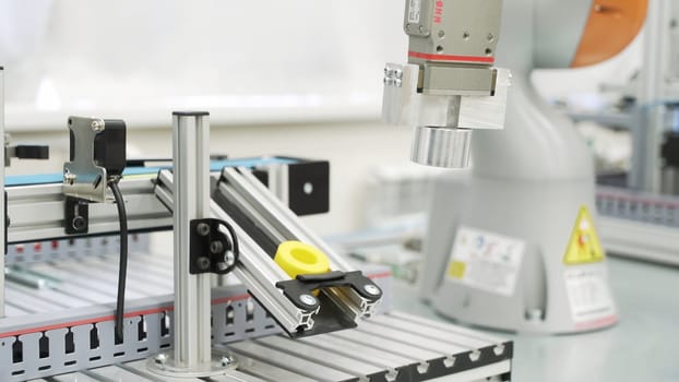 Close up of yellow object created by 3D printer in modern workshop. Technological background of robotic mechanism making a detail, science concept.