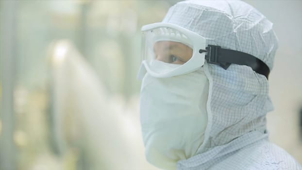 Worker in apron, cap, gloves with tablet checking process at production line in factory. Quality Control Workers Examining Pills in Lab. Pharmaceutical lab technicians inspecting the quality of medical pills.