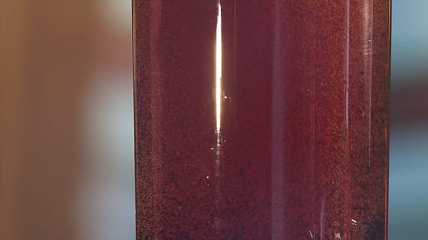 Gas bubbles float in a plastic bottle with dark blue liquid. Red liquid with bubbles in plastic bottle close up view.