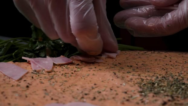 Hands preparing a pizza. Frame. Cook in the kitchen putting the ingredients on the pizza. Pizza concept. Production and delivery of food. Closeup hand of chef baker in white uniform making pizza at kitchen.