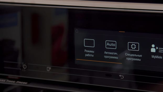 Close up of a black panel with small silver buttons on a microwave