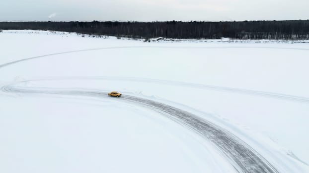 Aerial view of a race car moving fast through the snow desert. Clip. Concept of active lifestyle and sport