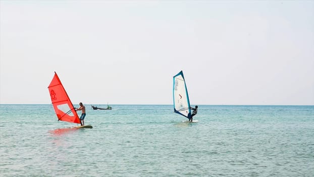 Windsurfer rides among the huge tubes and waves of the Indian Ocean on the island of Mauritius. Man ride Windsurfing.