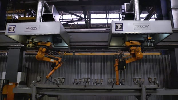 Moscow, Russia - September, 2018: Welding robots movement in car factory. Scene. Movement of robot when welding with sparks at factory of auto parts.