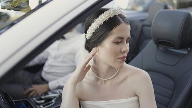 Beautiful couple in convertible. Action. Beautiful couple in festive elegant outfits in car. Couple in love in convertible on sunny summer day.