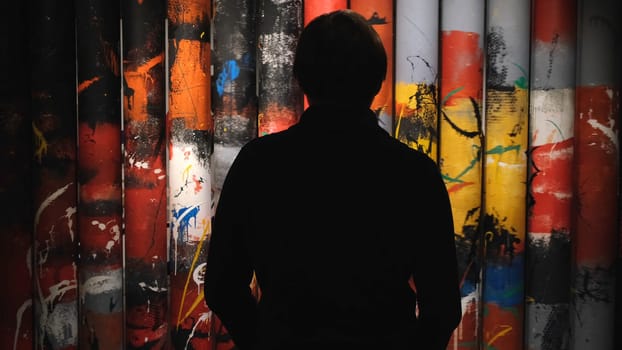 Unknown man looking at the beautiful paintings rotating on the rolls in the museum of Modern Art. Wheel of Samsara