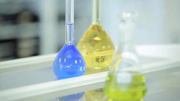 laboratory glassware with color liquid and with reflection. test tubes and flasks with green and blue liquid in a laboratory. Green and blue flask in laboratory. Fluid in laboratory flasks. Scientific biochemical laboratory. Red, blue, green, yellow liquid.