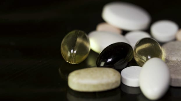 Pharmacy background on a dark table. Levitation pills. Tablets on a dark background which falling down. Pills. Medicine and healthy. Close up of capsules. Pills falling on black background.