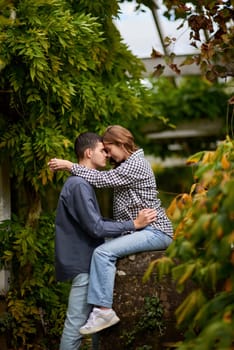 Young Cute Female Hugs Boyfriend. In Autumn Outdoor. Lovers Walking in Park. Attractive Funny Couple. Lovestory in Forest. Man and Woman. Cute Lovers in the Park. Family Concept. Happy Couple.